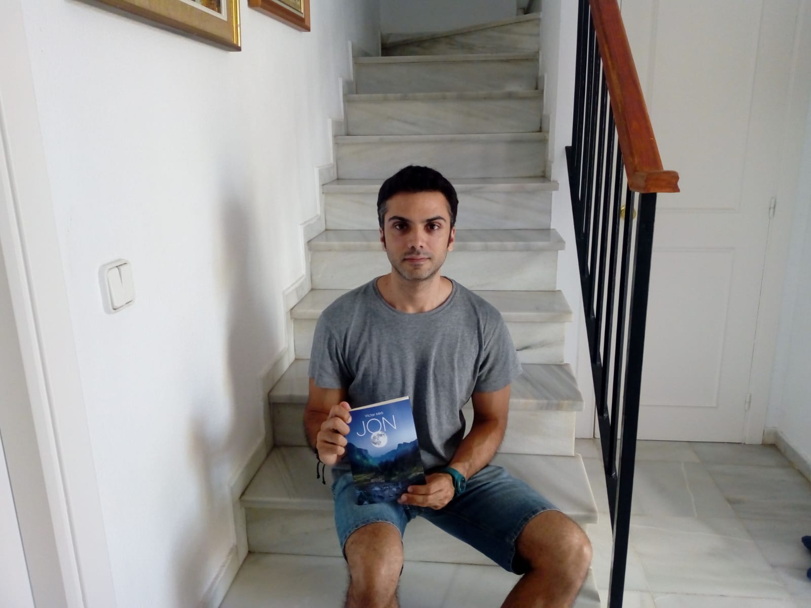 El escritor y actor andaluz, Víctor Miró, posando junto a su novela 'Jon'. 