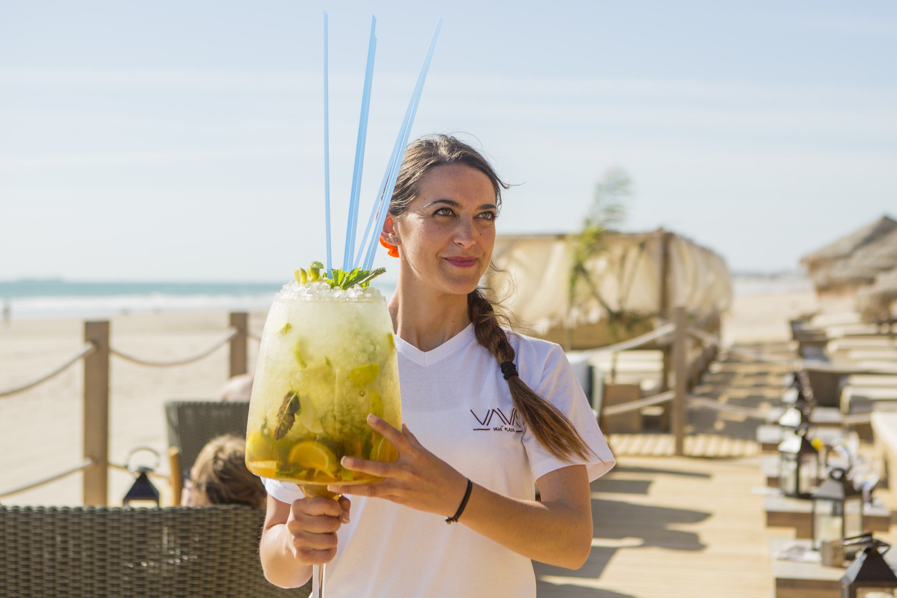 Una camarera sostiene un mojito gigante en el chiringuito de Chiclana Vavá Playa.