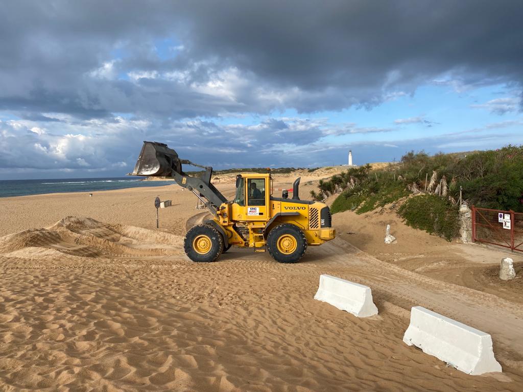 Operarios de Barbate retirando arena en el Faro Trafalgar.