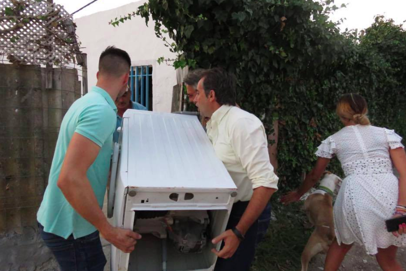 Antonio Saldaña, cargando con la lavadora a casa del vecino de la barriada rural de El Mojo.