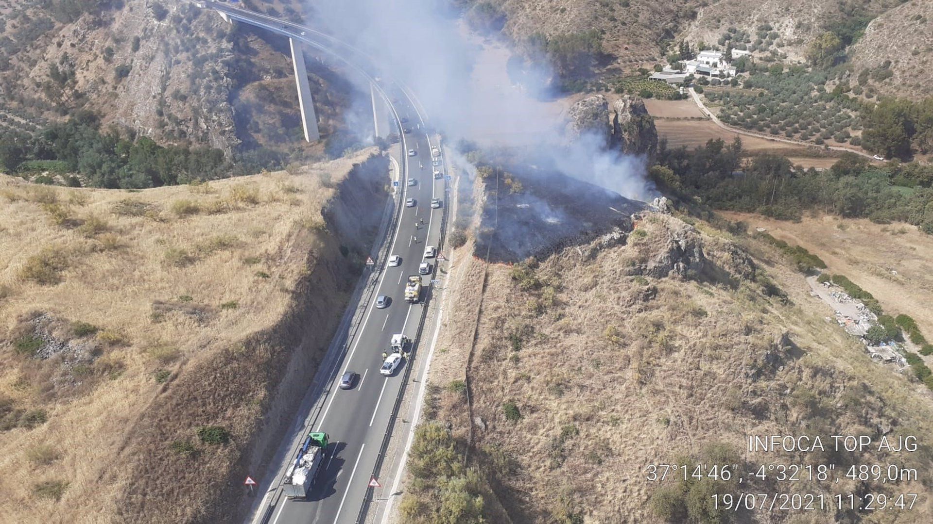 Vista aérea del incendio provocado por el accidente de un camión junto a la A-45 en Benamejí.  INFOCA