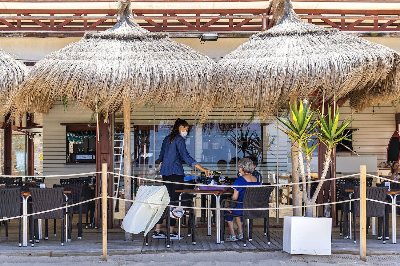 Una camarera en un chiringuito de Cádiz, donde baja el paro en julio.