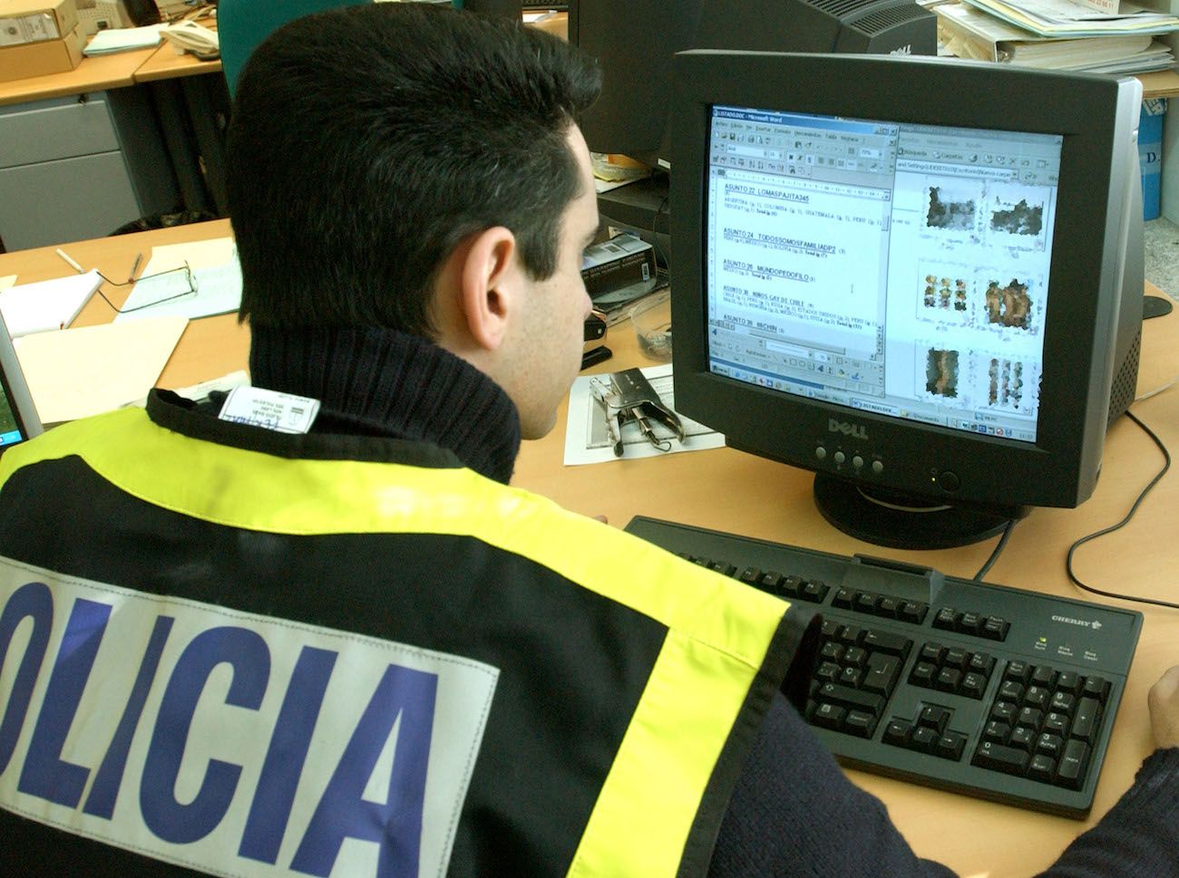 Un Policía, inspeccionando un equipo informático.