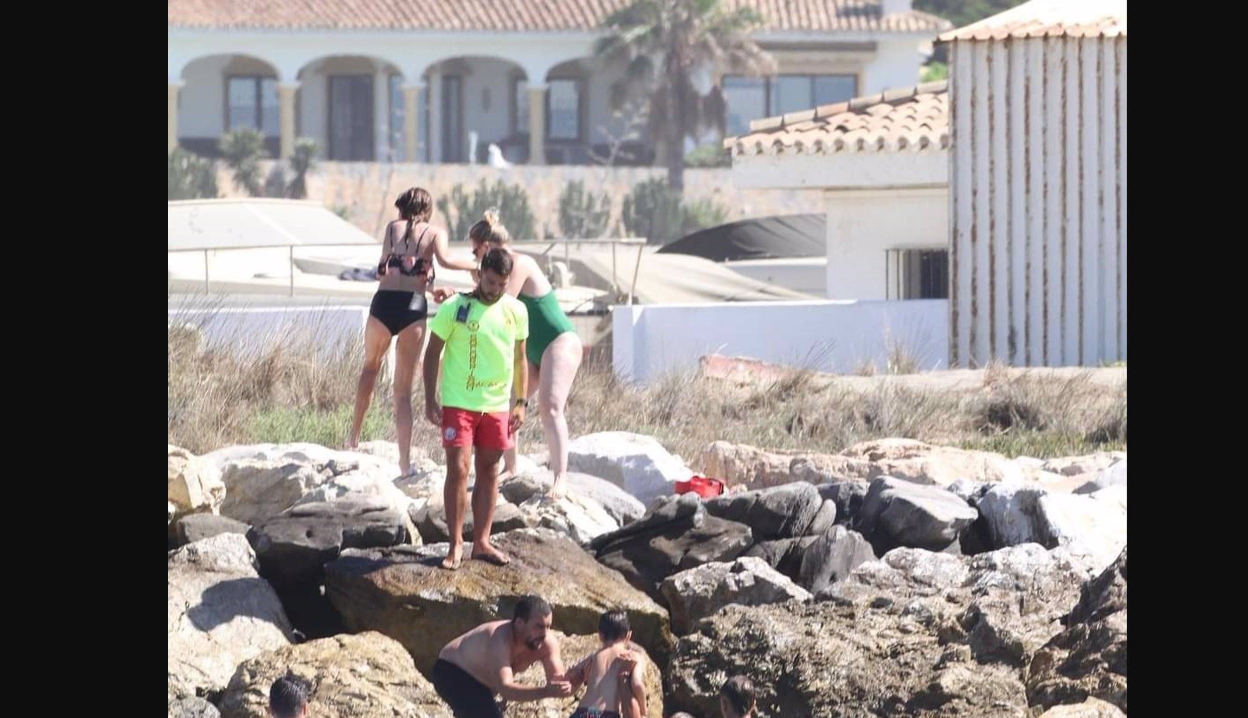 Los socorristas rescatan a los bañistas en una zona rocosa de la playa de Cabopino de Marbella