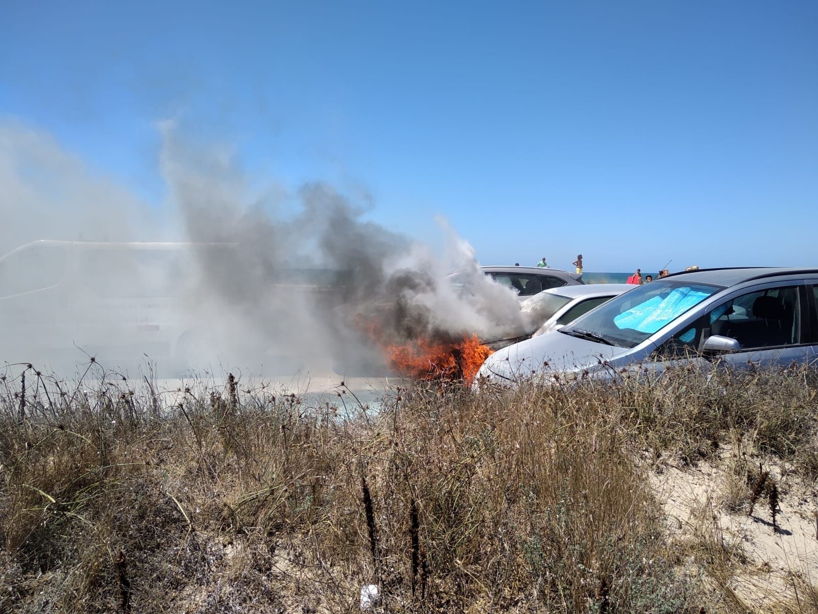 El coche incendiado en la playa de Cortadura en una fotografía de la Policía Local de Cádiz
