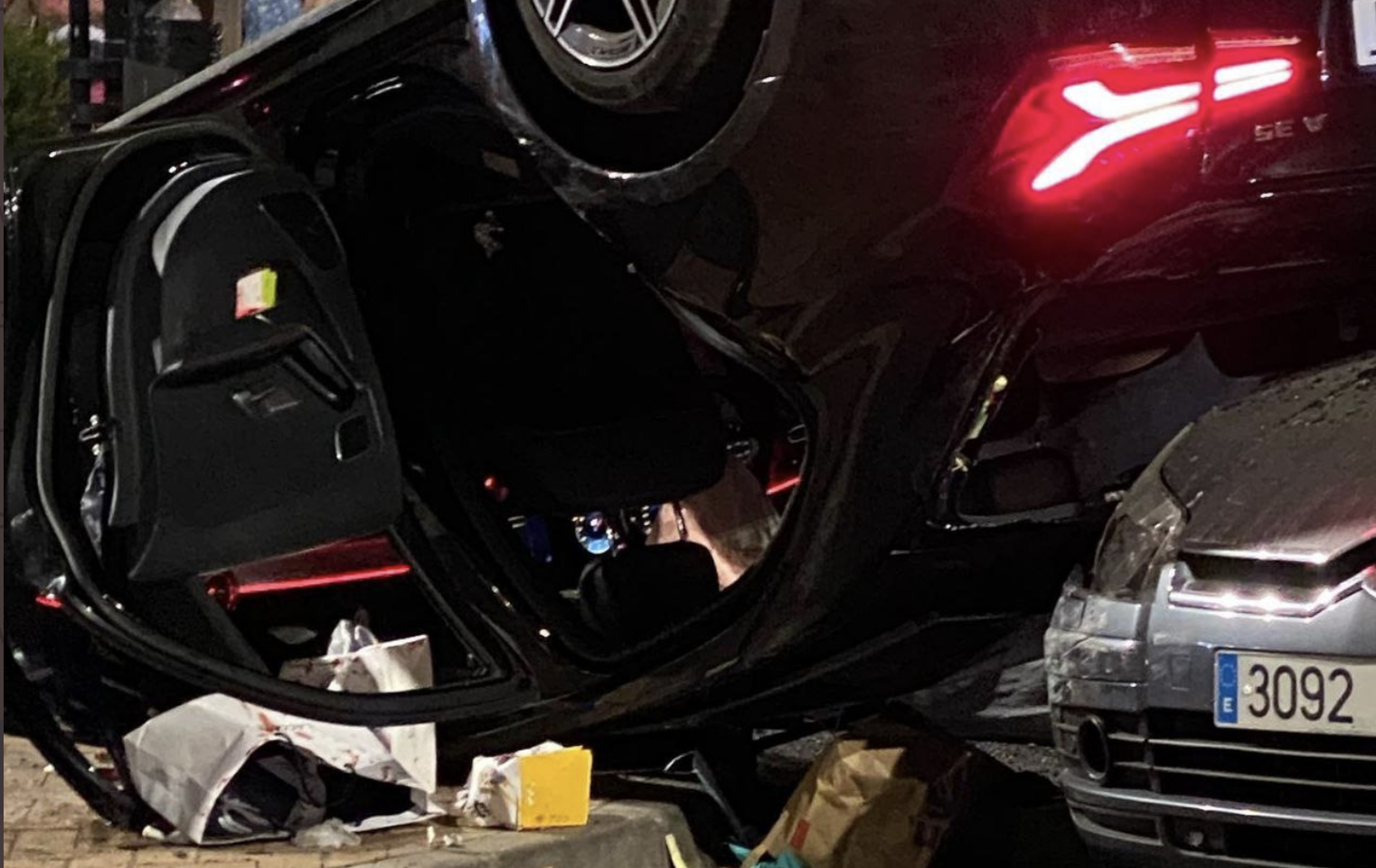 El Mercedes que conducía un joven francés de 20 años, volcado en la vía tras la fatal colisión.