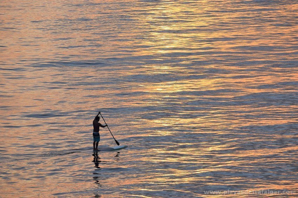 La fuerte corriente golpea contra las rocas a una joven que practicaba 'paddle surf' junto al Faro de Trafalgar. Una persona practica 'paddle surf', en una imagen de playas de Trafalgar.