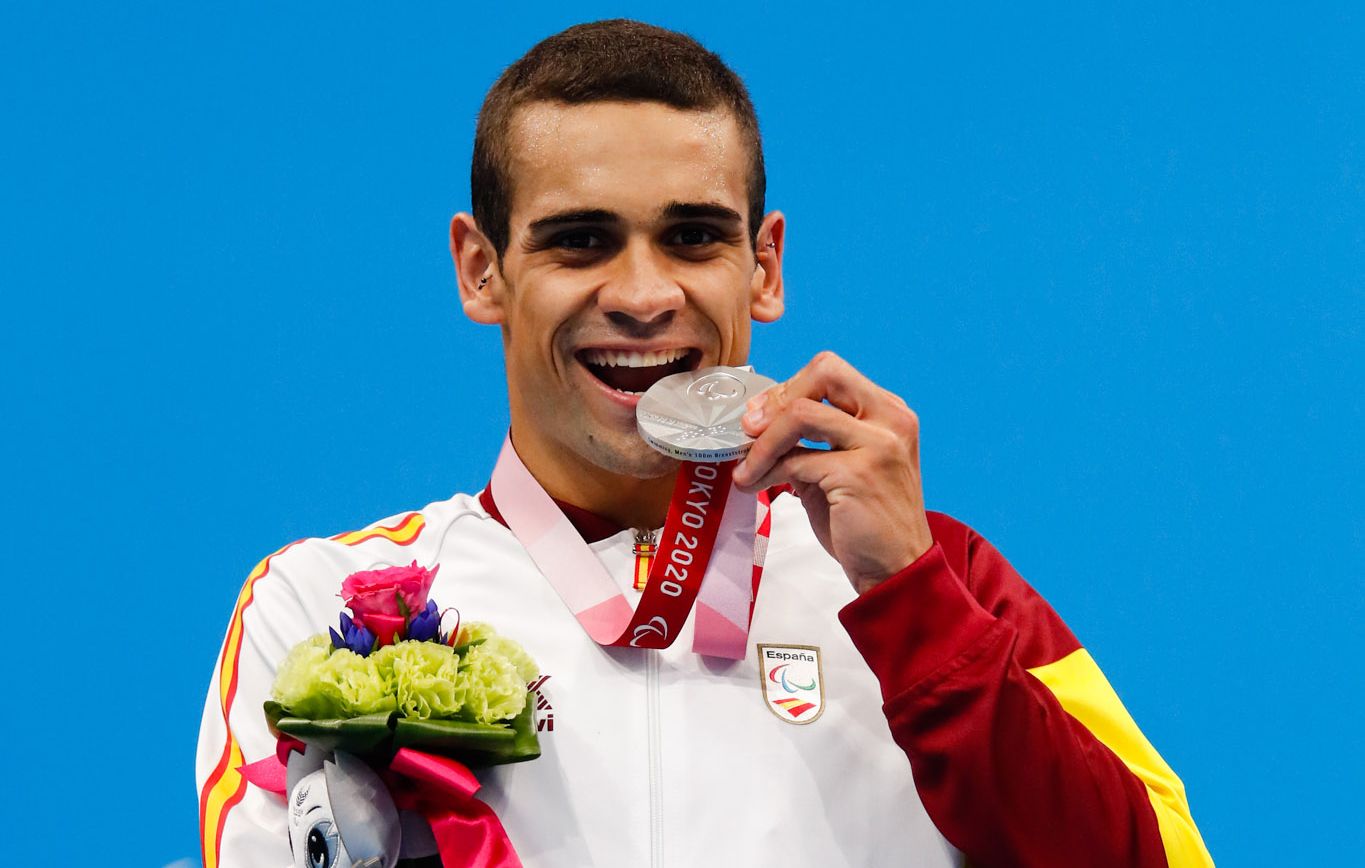 El nadador Óscar Salguero muerde la medalla de plata.