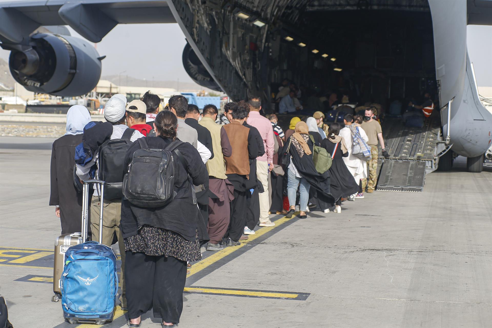 Refugiados afganos, subiendo a un avión en Kabul.