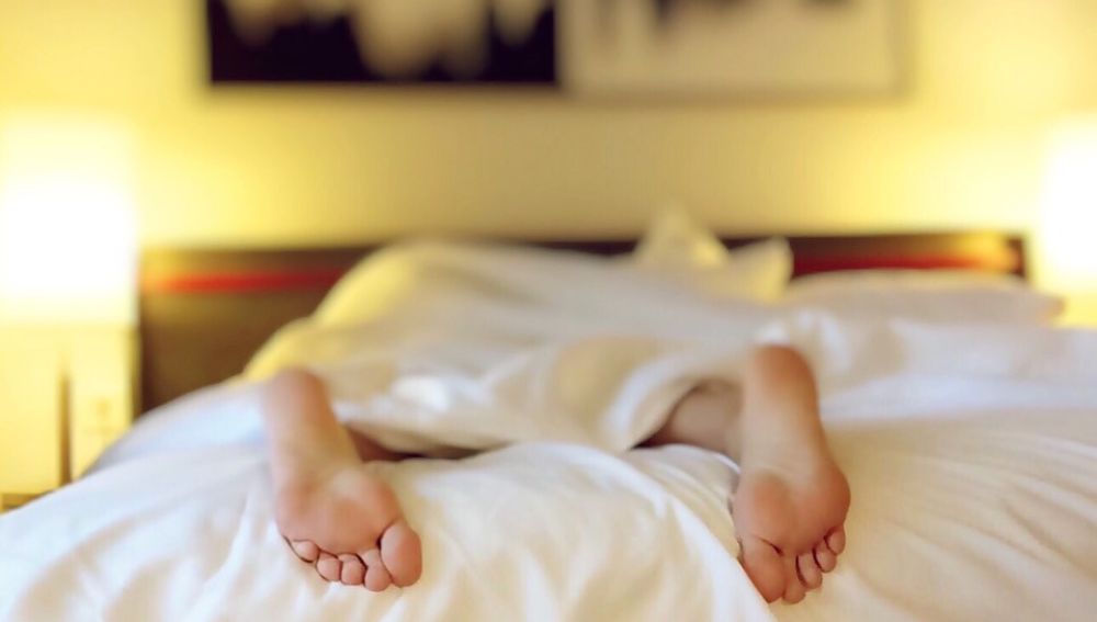 Una persona durmiendo boca abajo en la cama, en una imagen de archivo. 