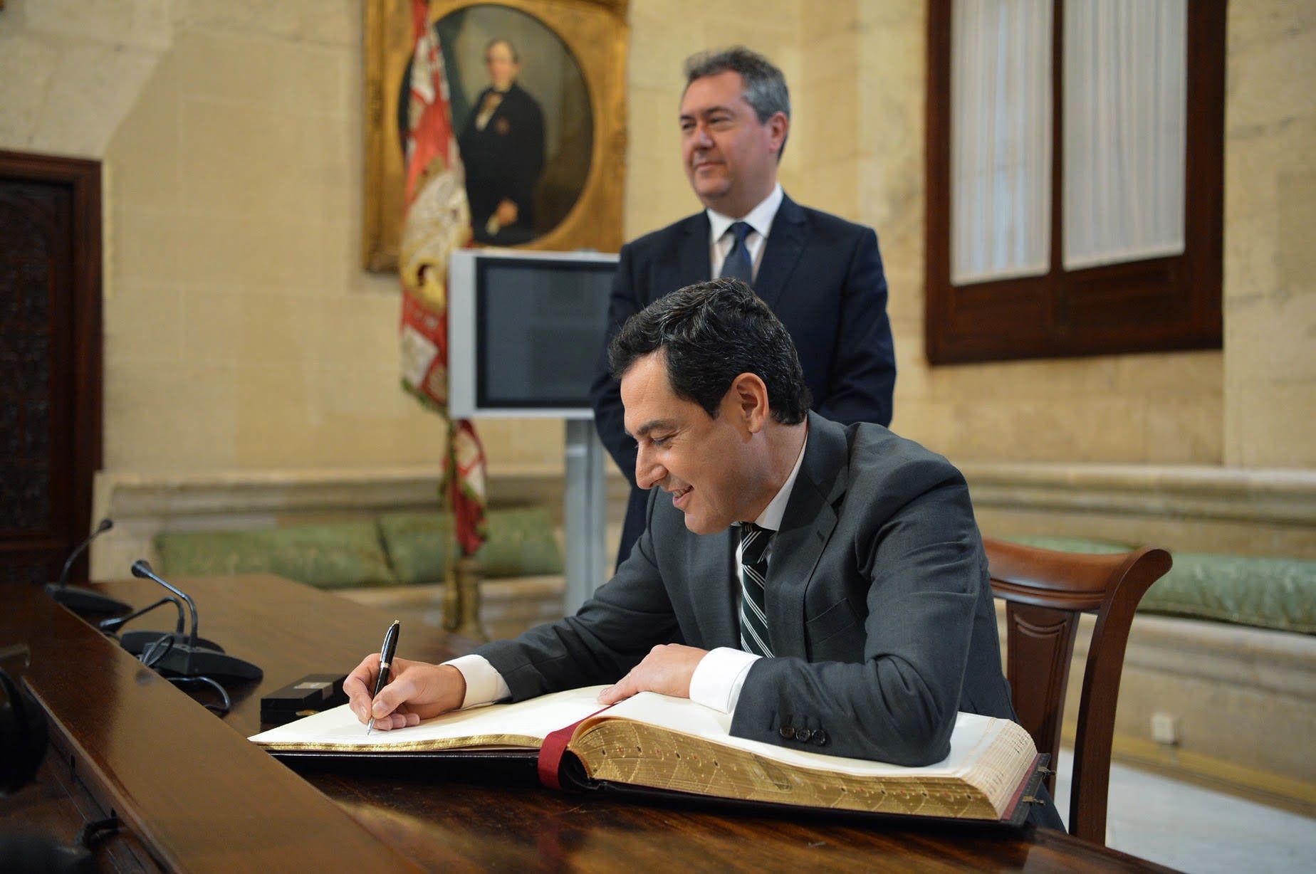 Moreno Bonilla firma en el libro de honor del Ayuntamiento de Sevilla, en presencia del alcalde Juan Espadas, en febrero de 2019. JUNTA