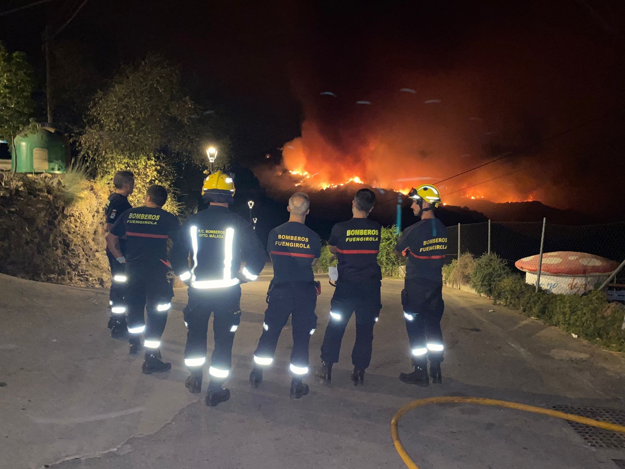 Bomberos de Fuengirola, con las llamas al fondo.