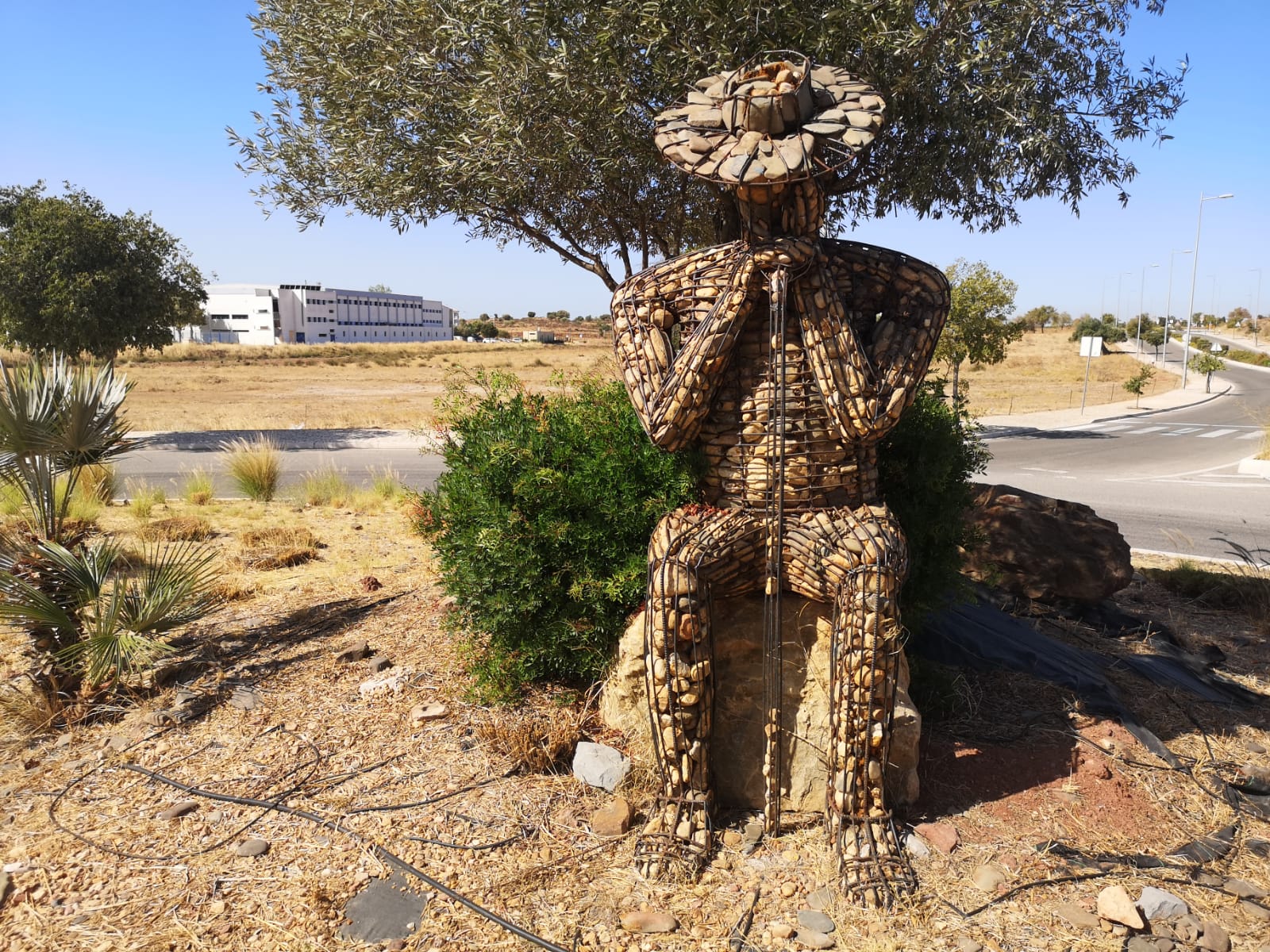 Escultura de piedras o bolos de río de un pastor, con armadura de hierro en una rotonda de Castro Marim.
