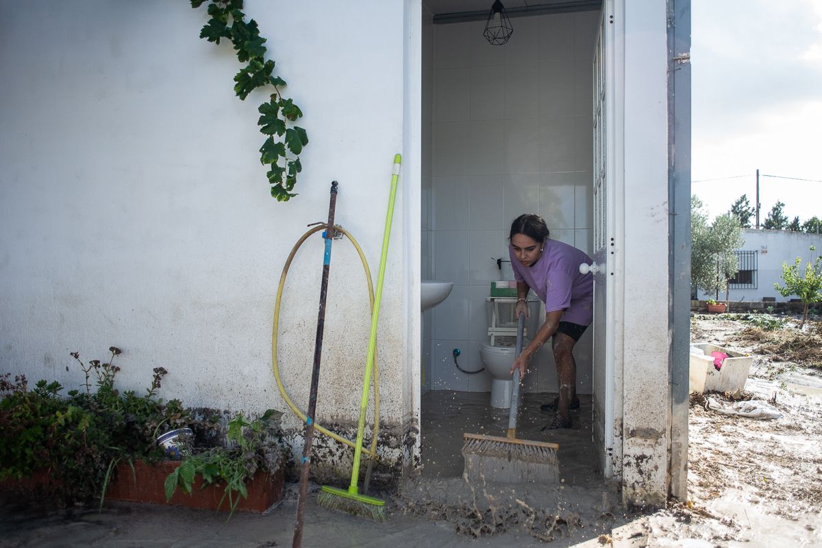 Una vecina limpiando el barro.