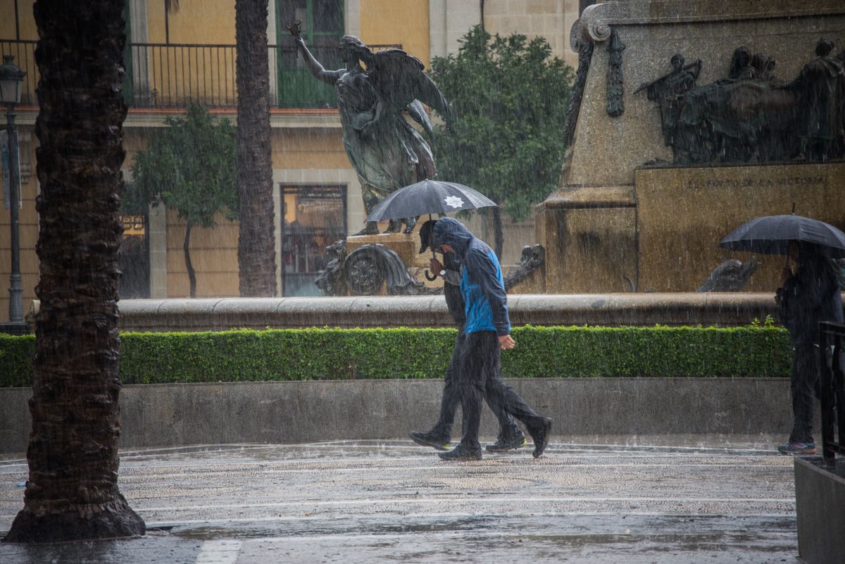 Dos personas en la plaza de la Arenal bajo la lluvia. FOTO: MANU GARCÍA.