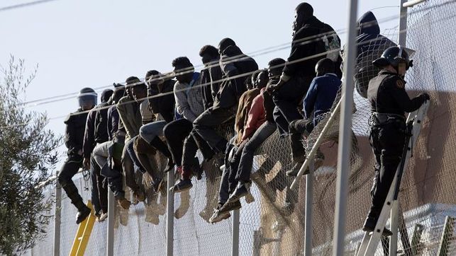 Migrantes sobre la valla de Melilla. FOTO: ELDIARIO.ES.
