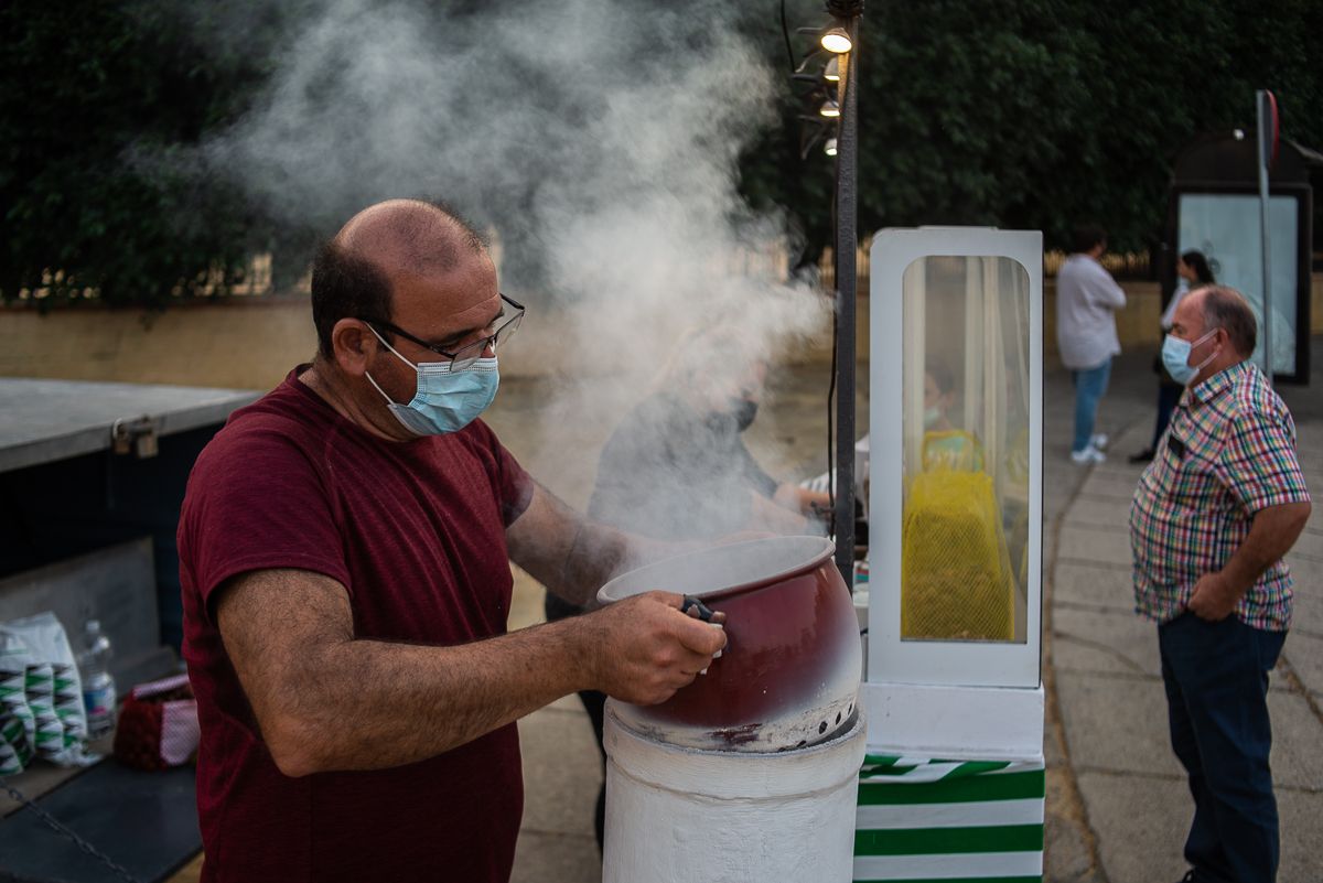 Rafael, con Mari al fondo, preparan castañas en el puesto que tienen junto a Ifeca.