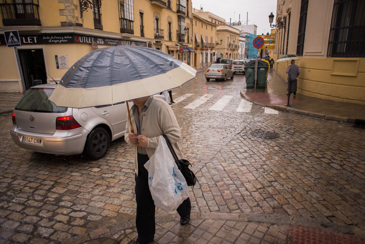 Un hombre se refugia con un paragüas bajo la lluvia en Andalucía, que se salva de un chorro de aire polar con temperaturas gélidas.