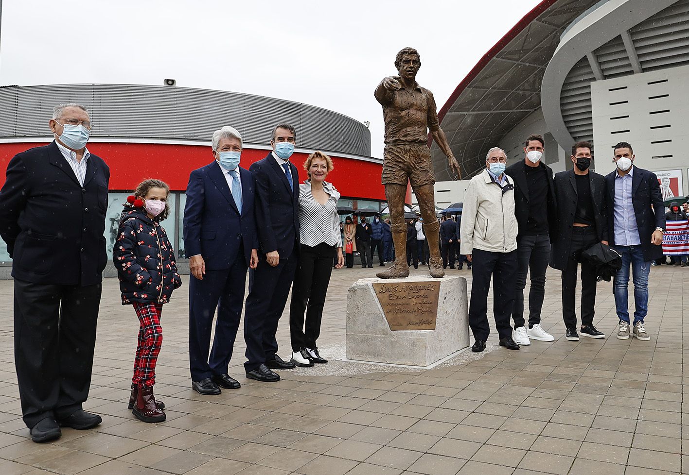 Dirigentes y familiares, junto a la estatua de Luis Aragonés, leyenda del Atlético y de la selección española, en el Wanda Metropolitano.   @ATLETI