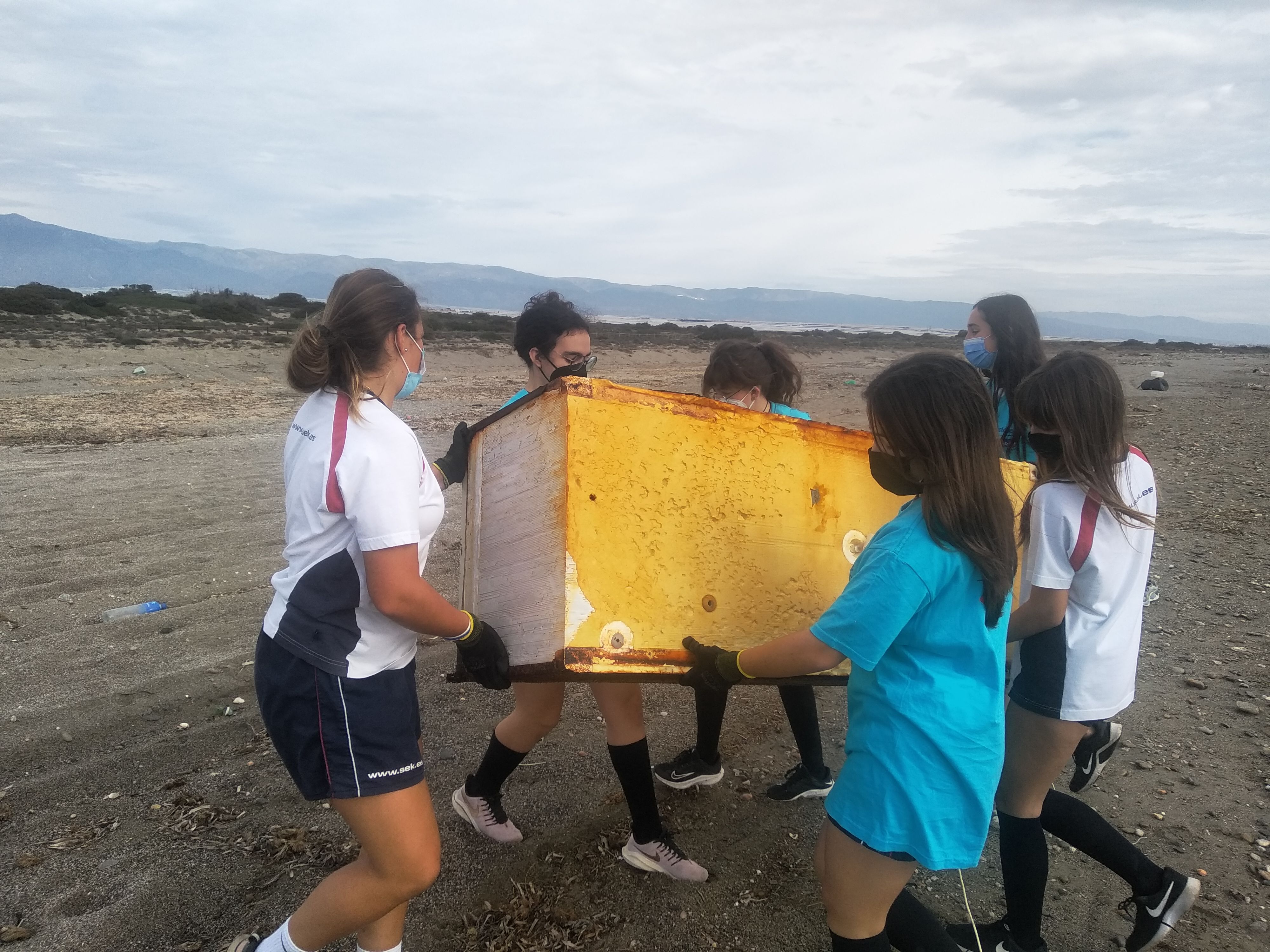 Varios jóvenes limpian la playa del Faro del Sabinal, en Punta Entinas, Almería.