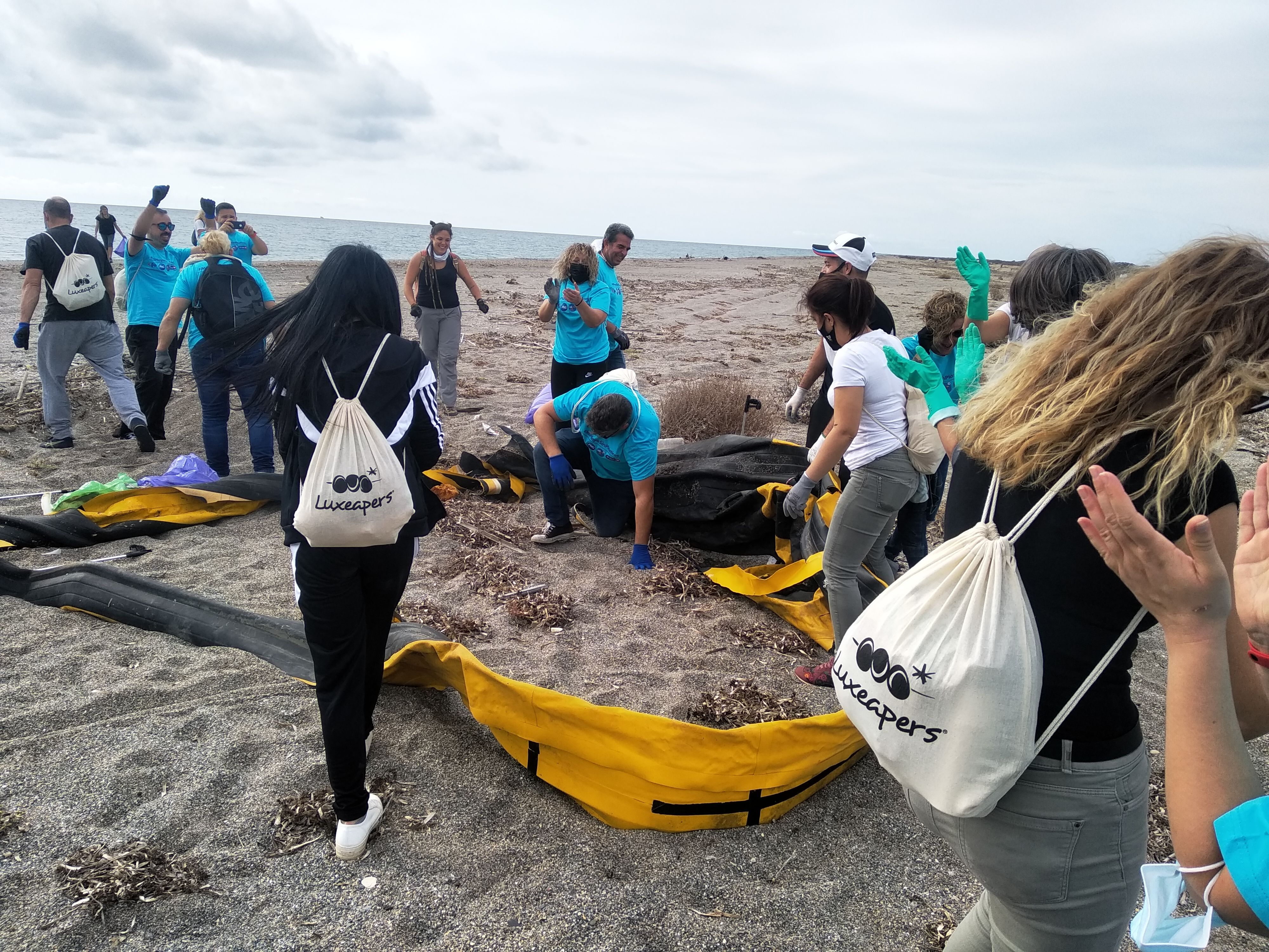 Jóvenes recogiendo la basura de la playa.