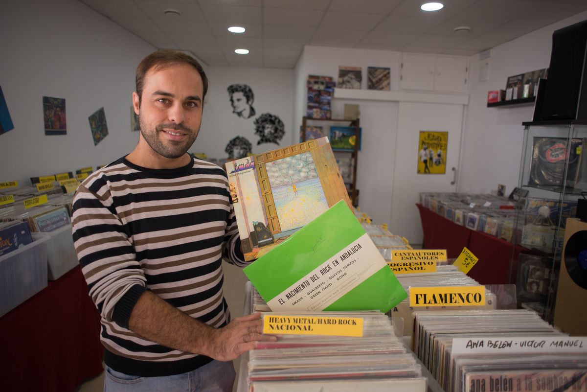 Juan de Dios Fernández Calero, regente de Discosxmil, sostiene un vinilo de Imán Califato Independiente y un recopilatorio de rock andaluz. FOTO: MANU GARCÍA.