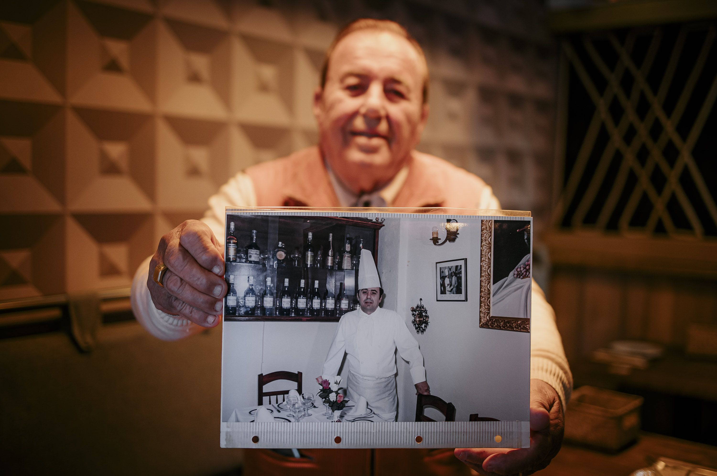 Juan Hurtado, en días pasados en La Espartería, sujeta una foto de su época con gorro blanco en restaurante Gaitán, alta cocina vasco andaluza que hizo raya.
