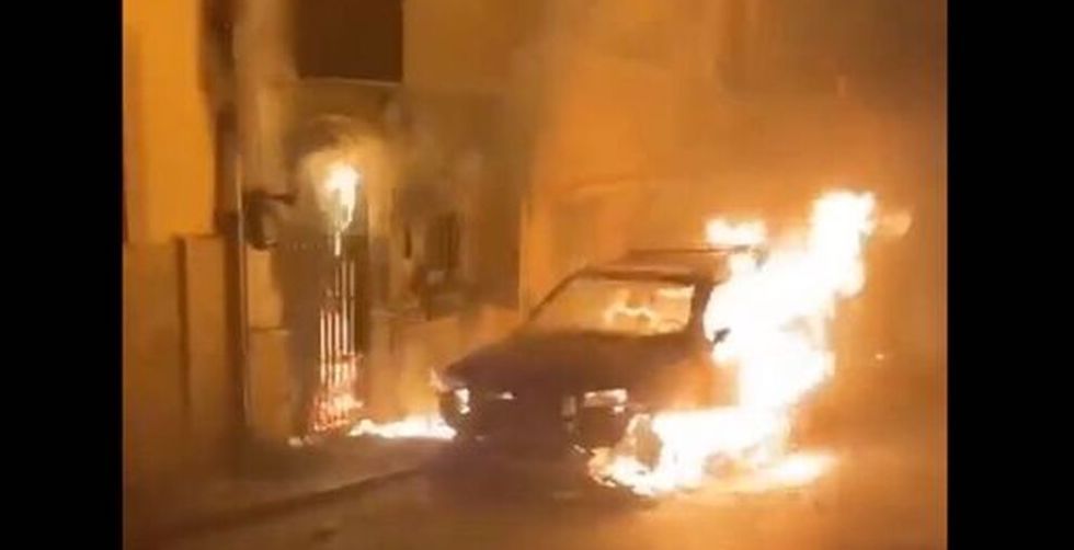 Un coche ardiendo delante de la casa del alcalde de Navas de San Juan.