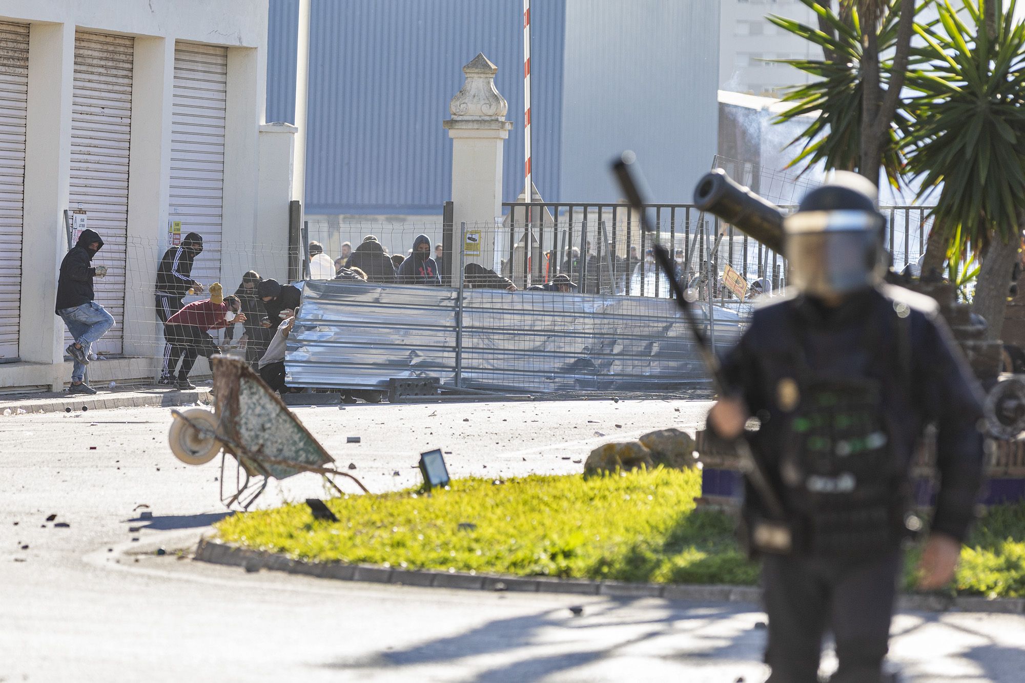 Un agente policial, con manifestantes del metal de fondo.