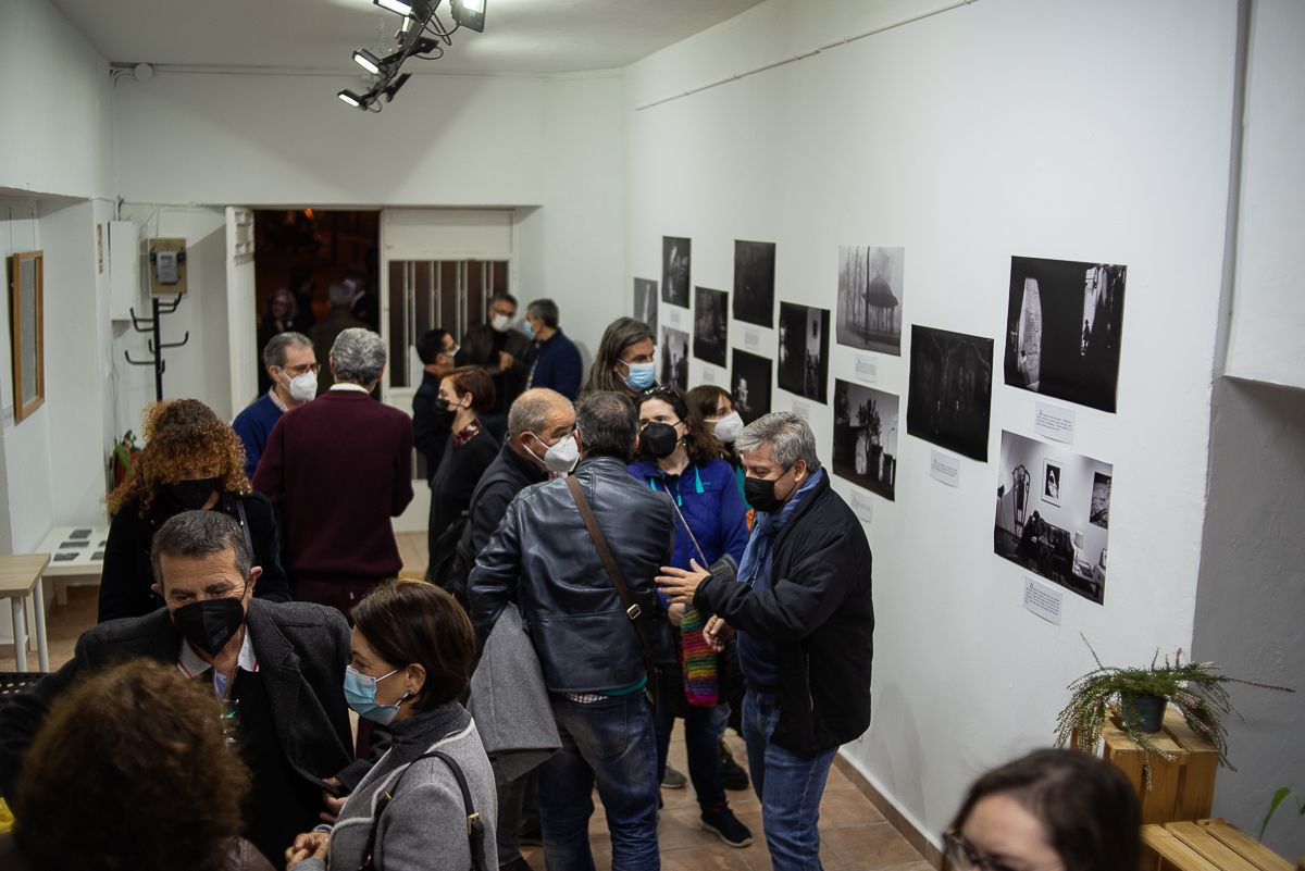 Los asistentes contemplan las fotografías en la sala Tragaluz.