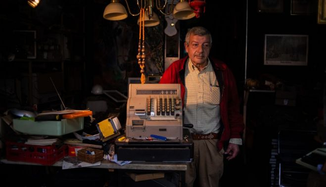 Antonio Arroyo, con una caja registradora que tiene en su tienda de Porvera.