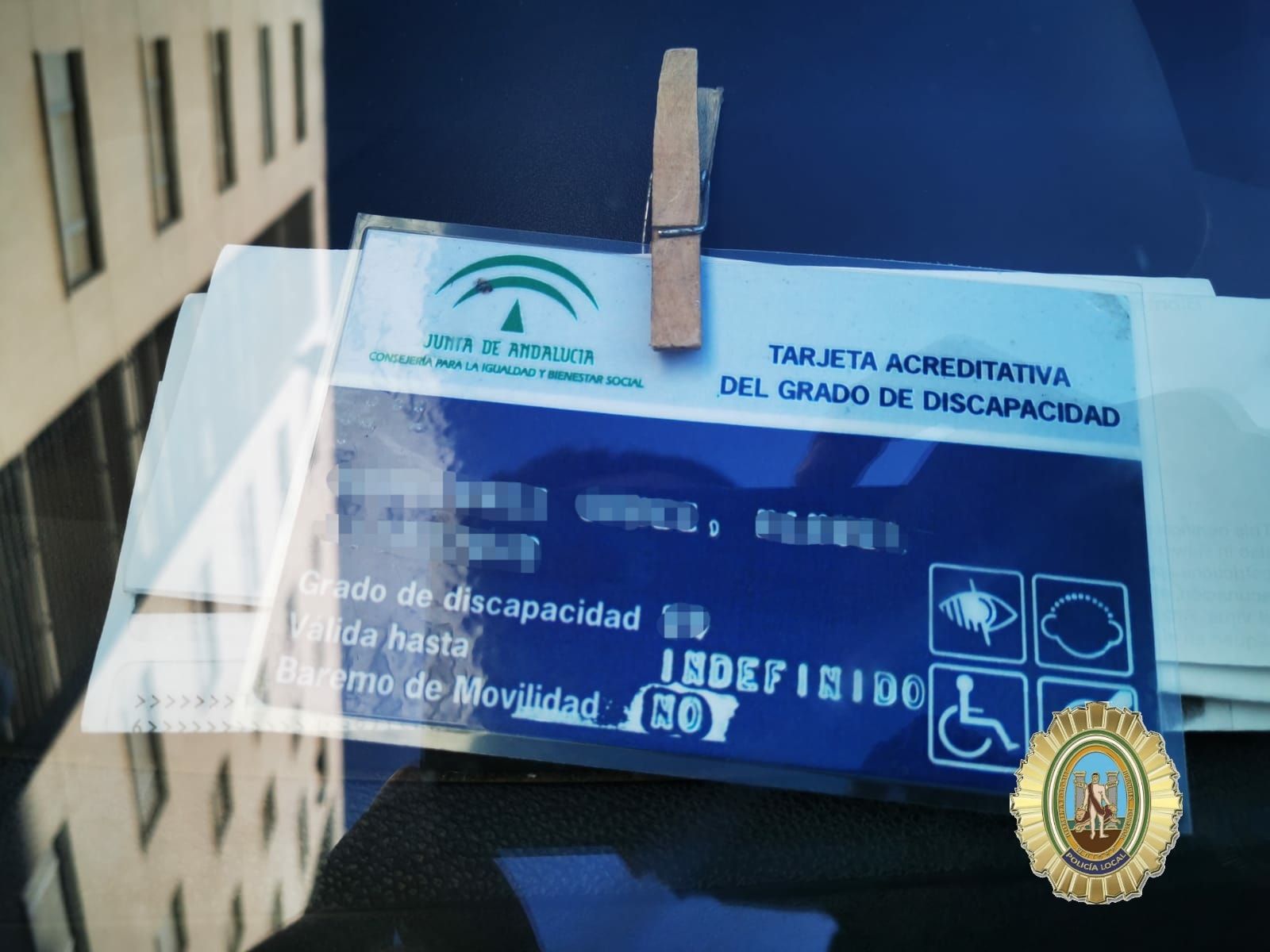 Un vecino aparca en una zona reservada para minusválidos con una tarjeta acreditativa del grado de discapacidad.