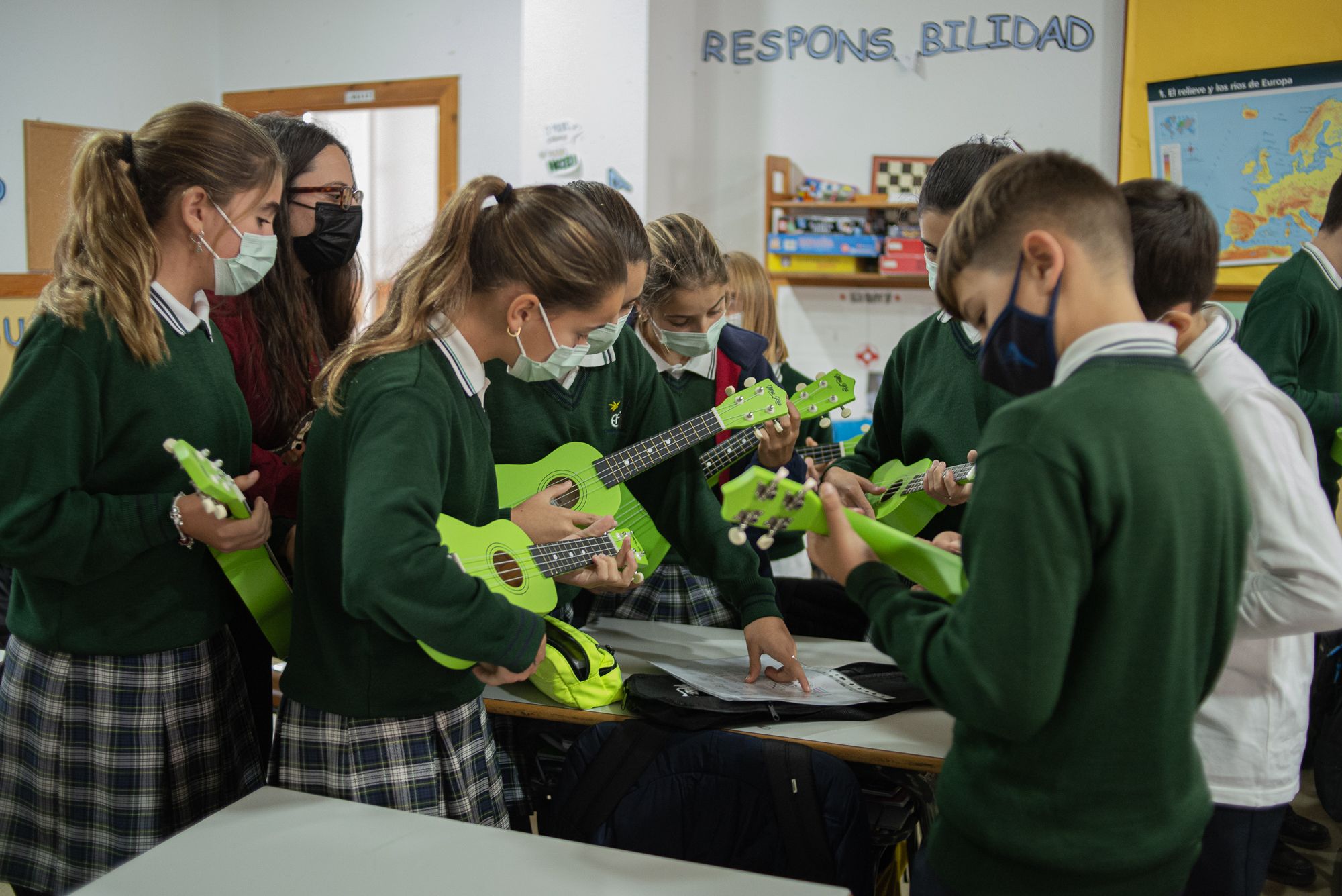 Un grupo de alumnos y alumnas afinando sus ukeleles.