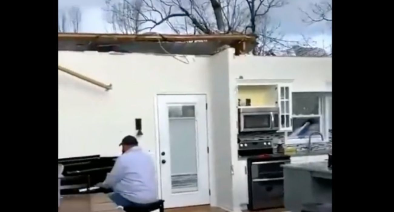 El hombre tocando el piano, con su casa destrozada. 