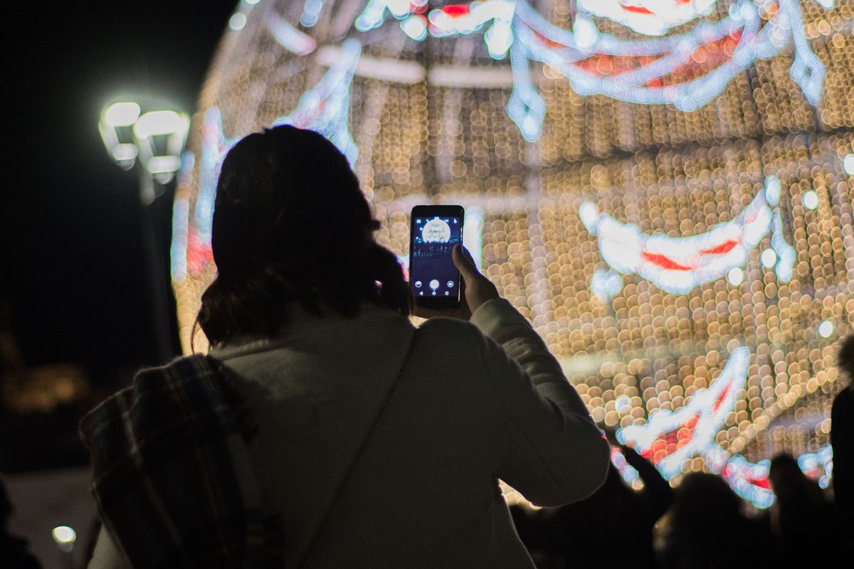 Una mujer haciéndole una foto a la bola de la plaza Belén. FOTO: MANU GARCÍA. 
