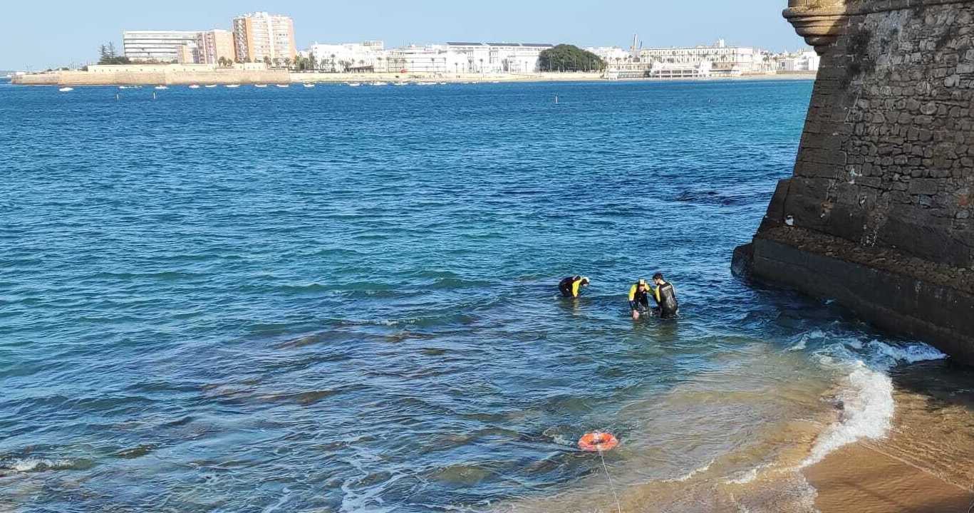 Bomberos rescatando el cuerpo del joven fallecido en Cádiz.