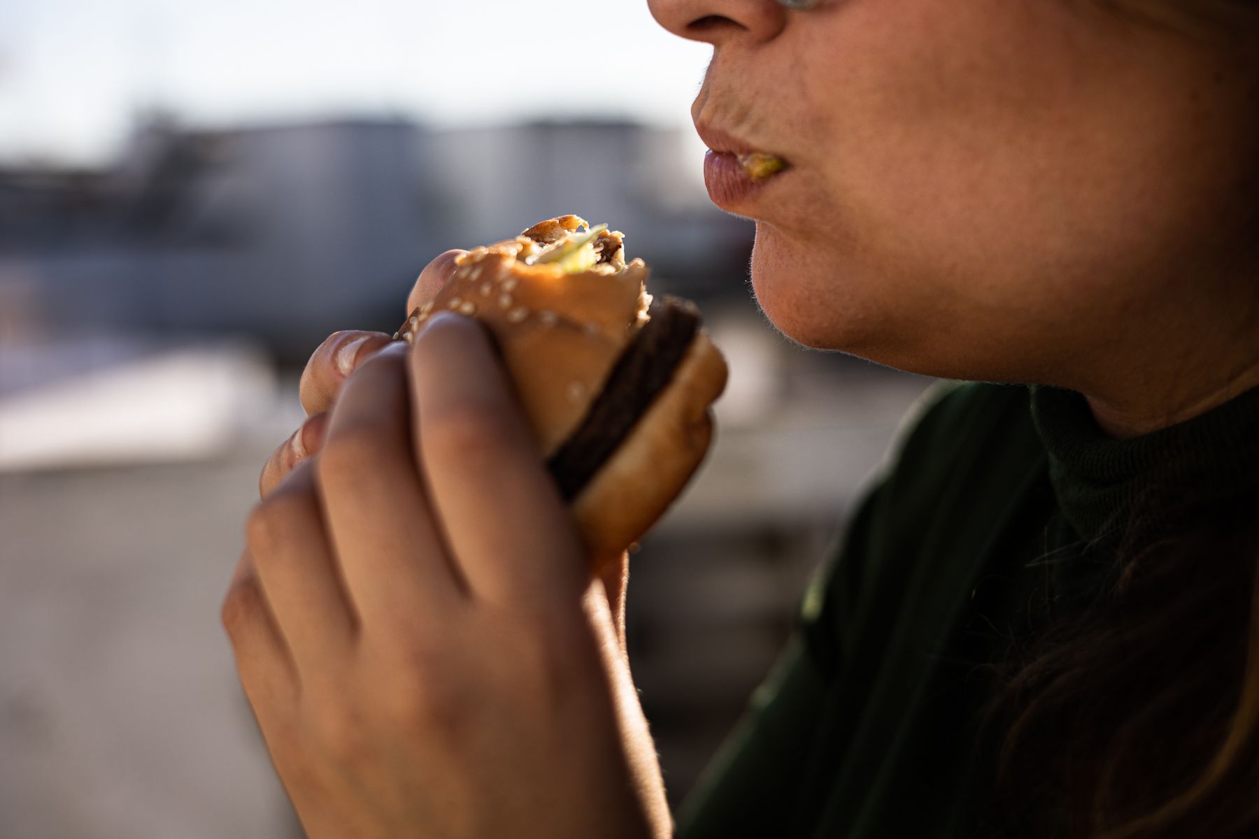 Una persona comiendo una hamburguesa. 