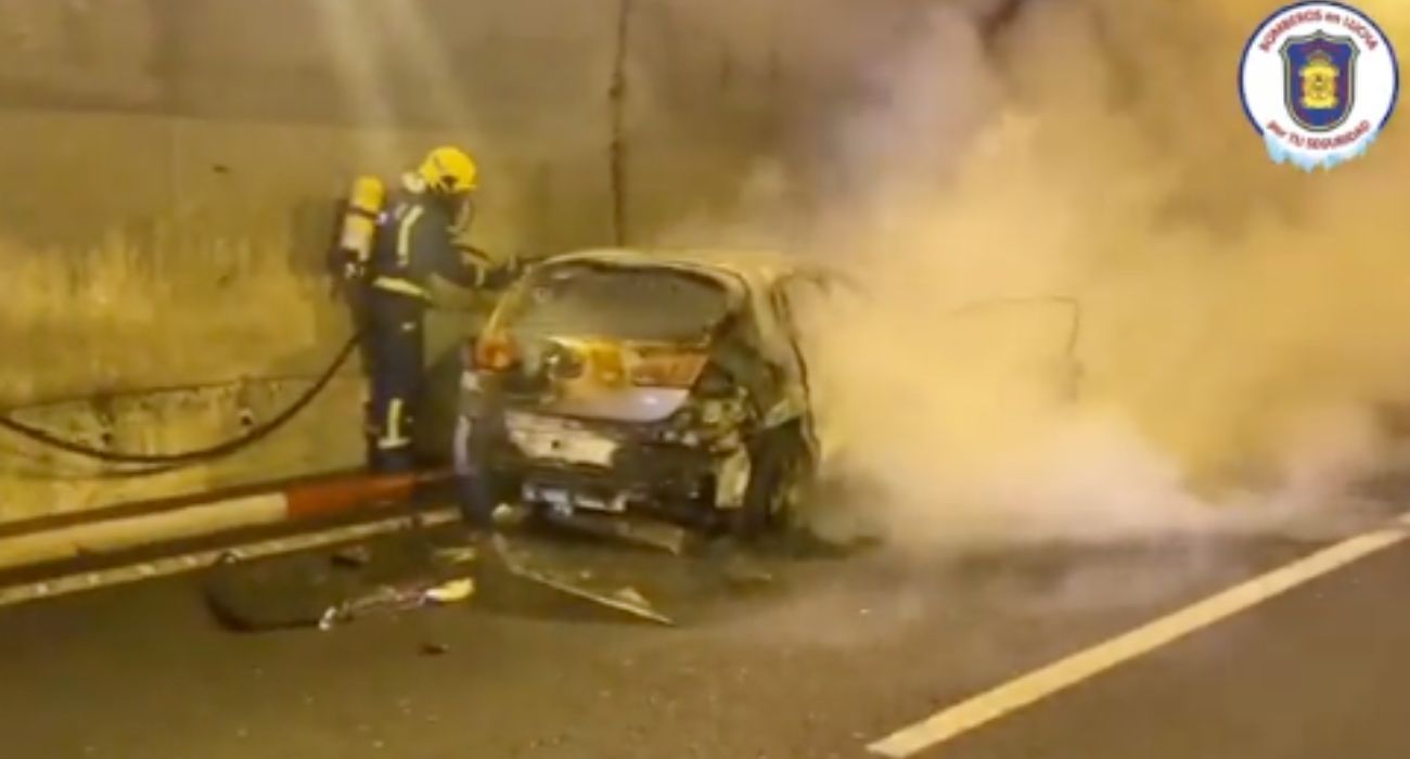 Bomberos de Málaga apagan el fuego del coche robado.