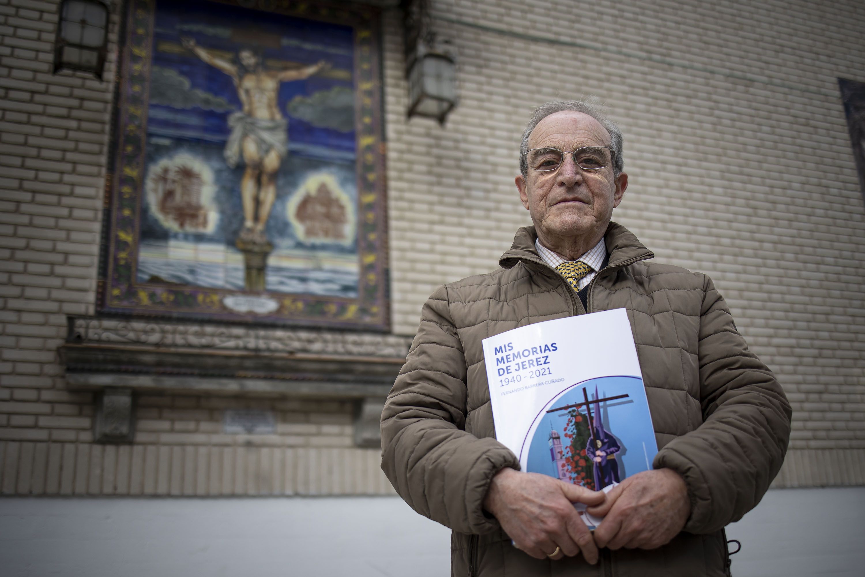 Barrera Cuñado, con su libro, posando ante el azulejo del Cristo de la Defensión en la fachada de Capuchinos.