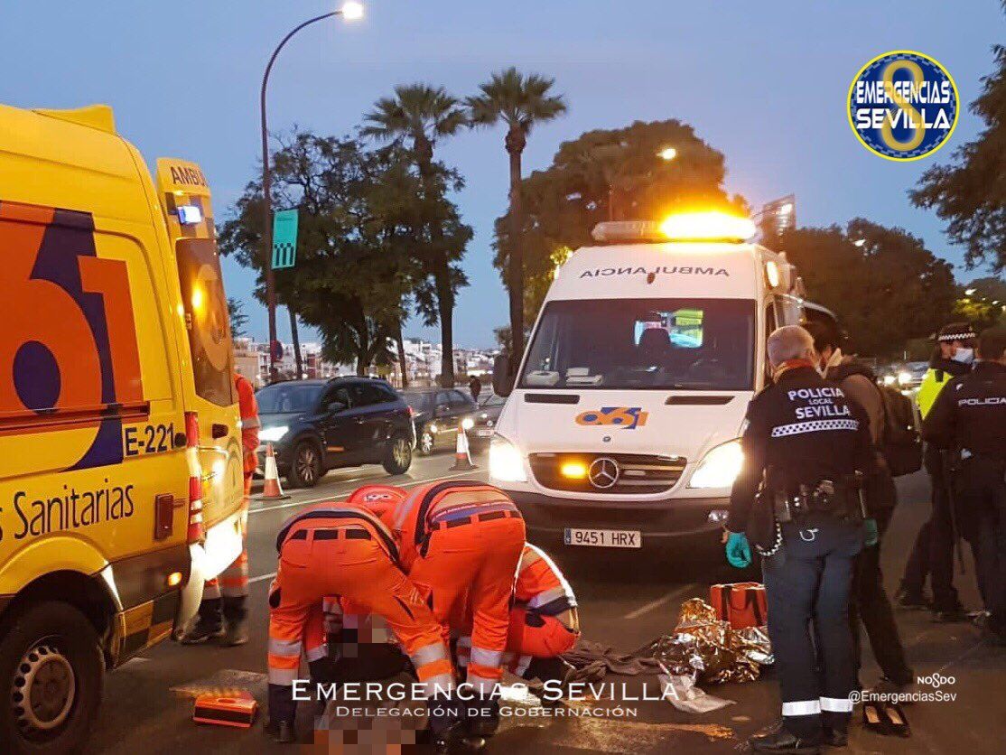 Efectivos de emergencias atendiendo a la mujer que ha sufrido heridas graves en la cara tras perder el control de su moto en Sevilla. 