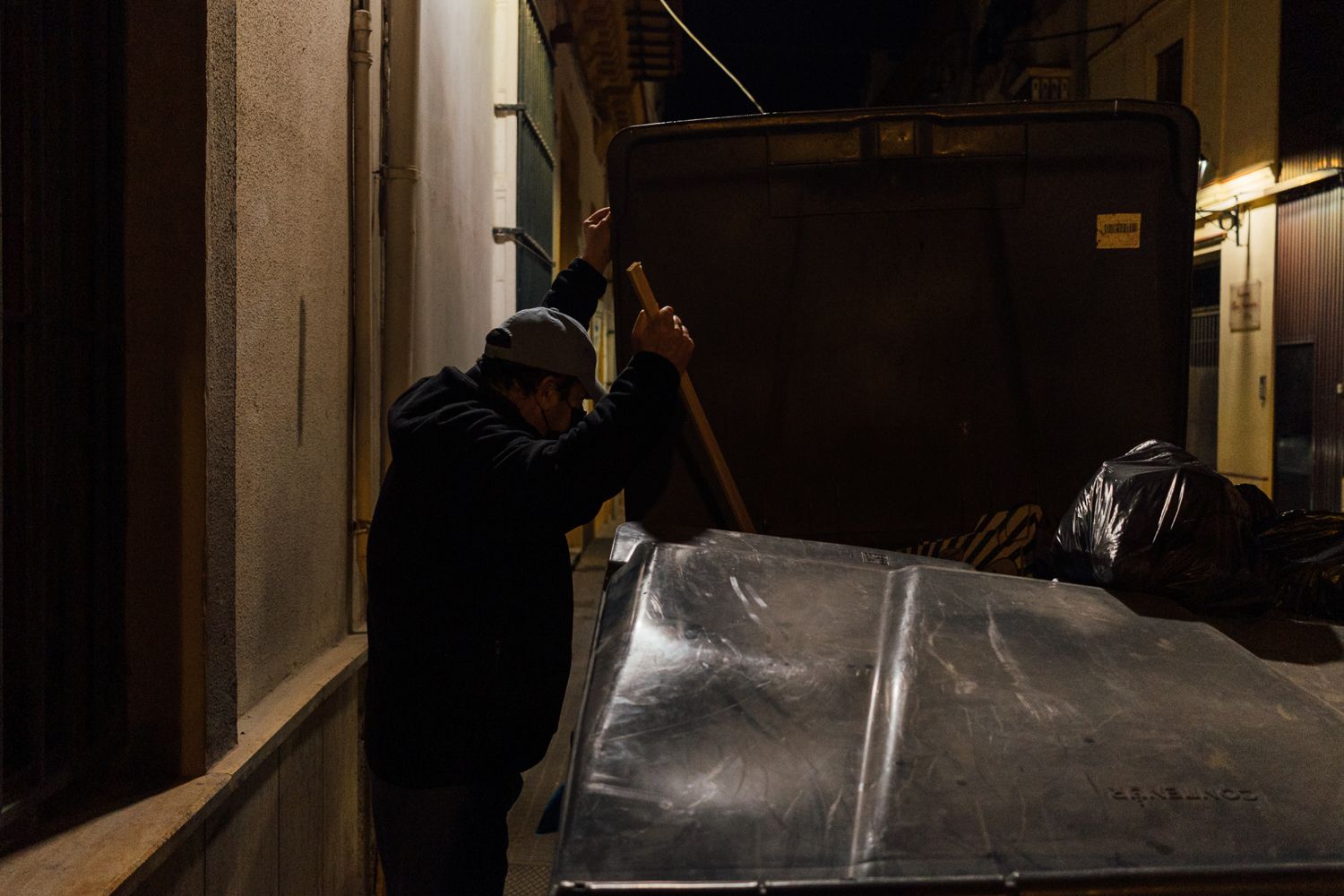 Una persona busca comida en un contenedor. Una persona busca comida en un contenedor.