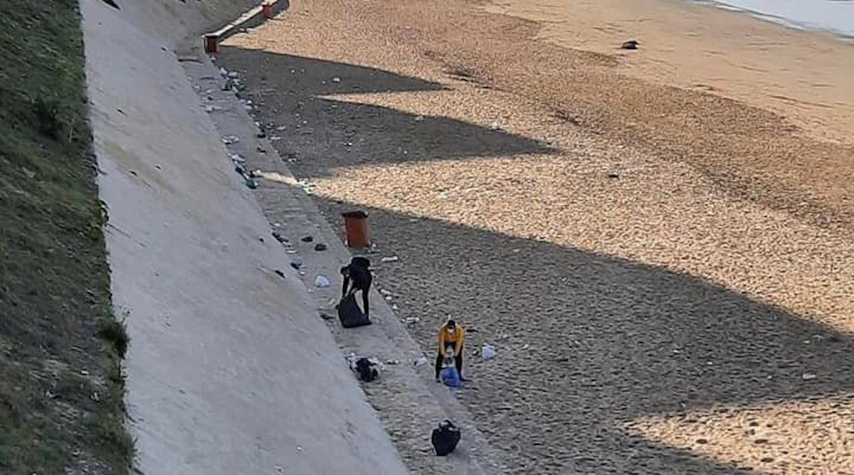 Varios vecinos recogen la basura del botellón en la playa