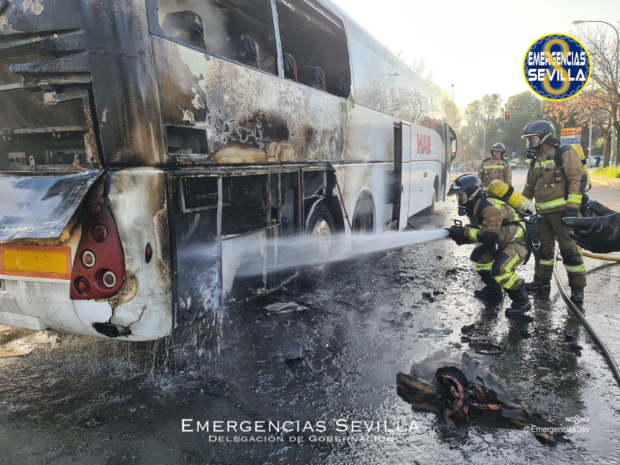 Bomberos de Sevilla apagan el fuego en un autobús de Sevilla, incendiado en la Ronda Norte