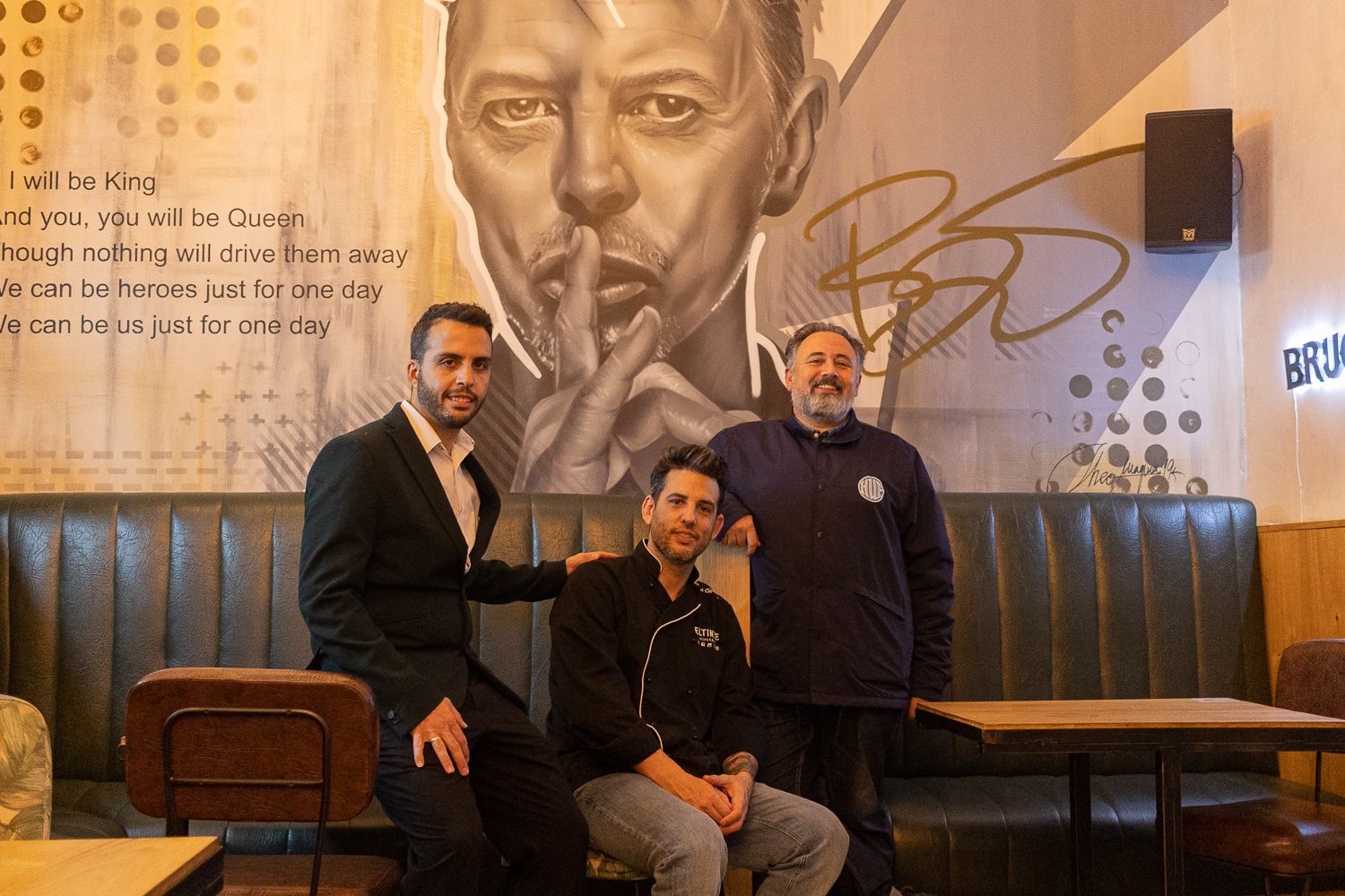 Daniel Ogalla con Rafael Butrón e Isaac junto al grafiti de David Bowie en el superbar El Tinte en Cádiz.