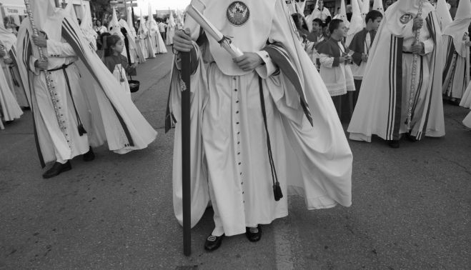 Nazarenos vistiendo la característica túnica inspirada en el hábito de las Hermanas de la Caridad.    MANU GARCÍA