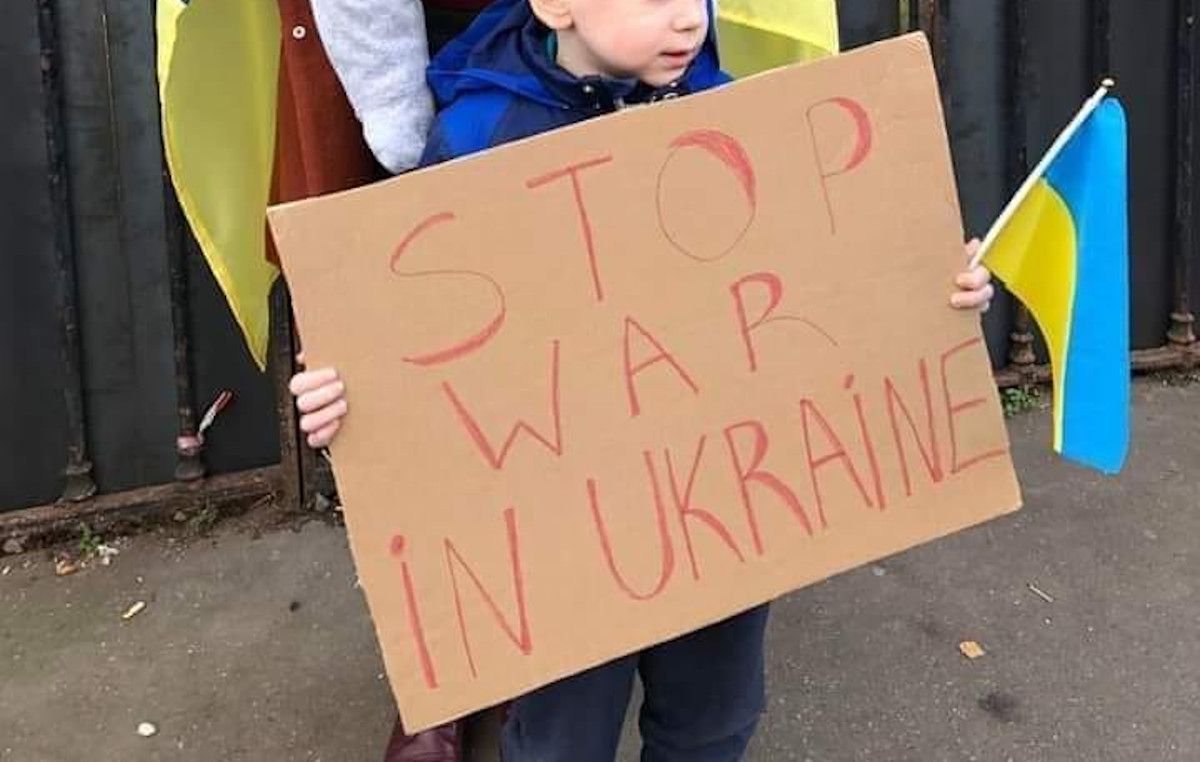 Un niño ucraniano sujeta un cartel en contra de la guerra en su país