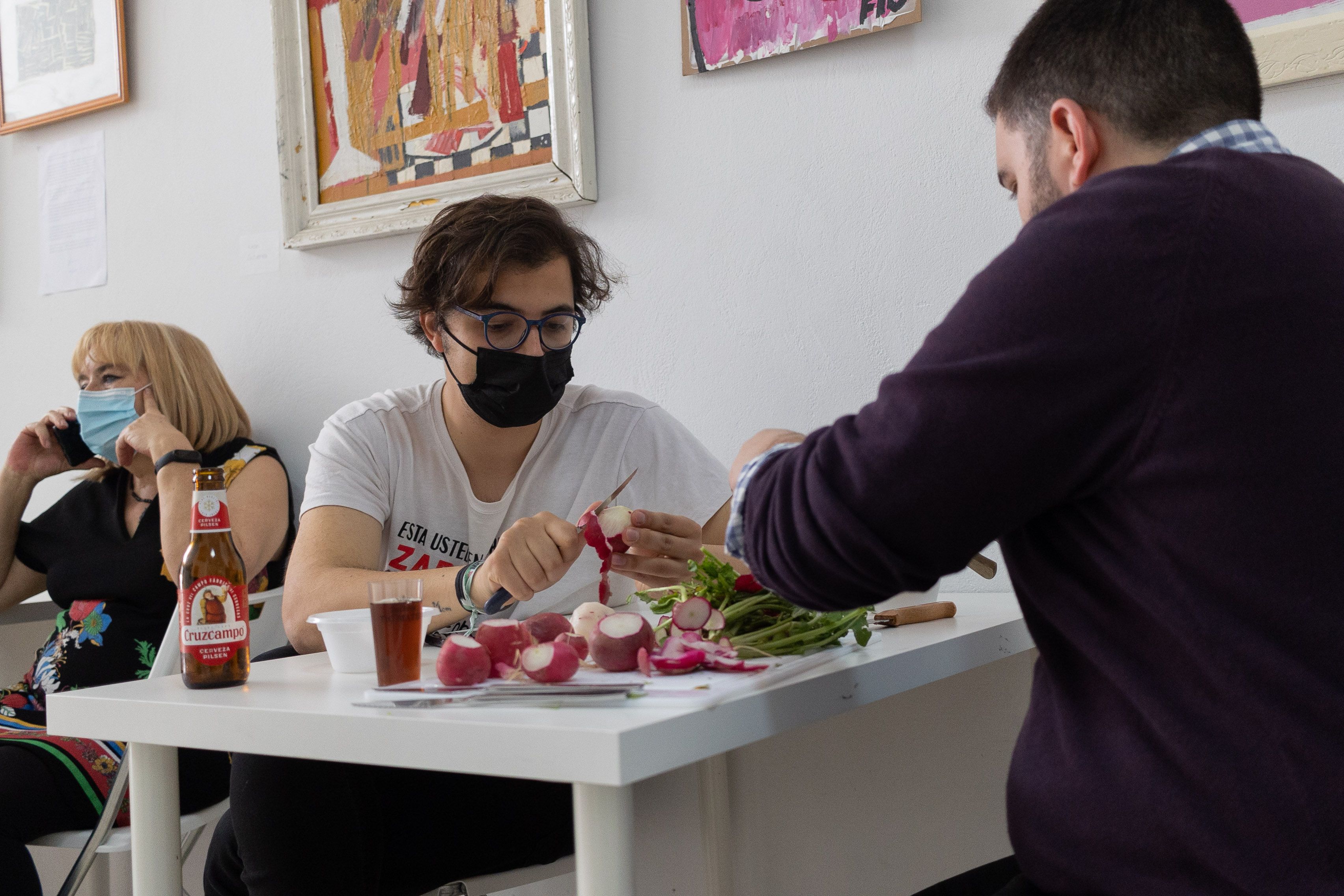 Algunos de los miembros de La Yerbabuena pelando rabanitos para acompañar el ajo campero en la convivencia pre-28F