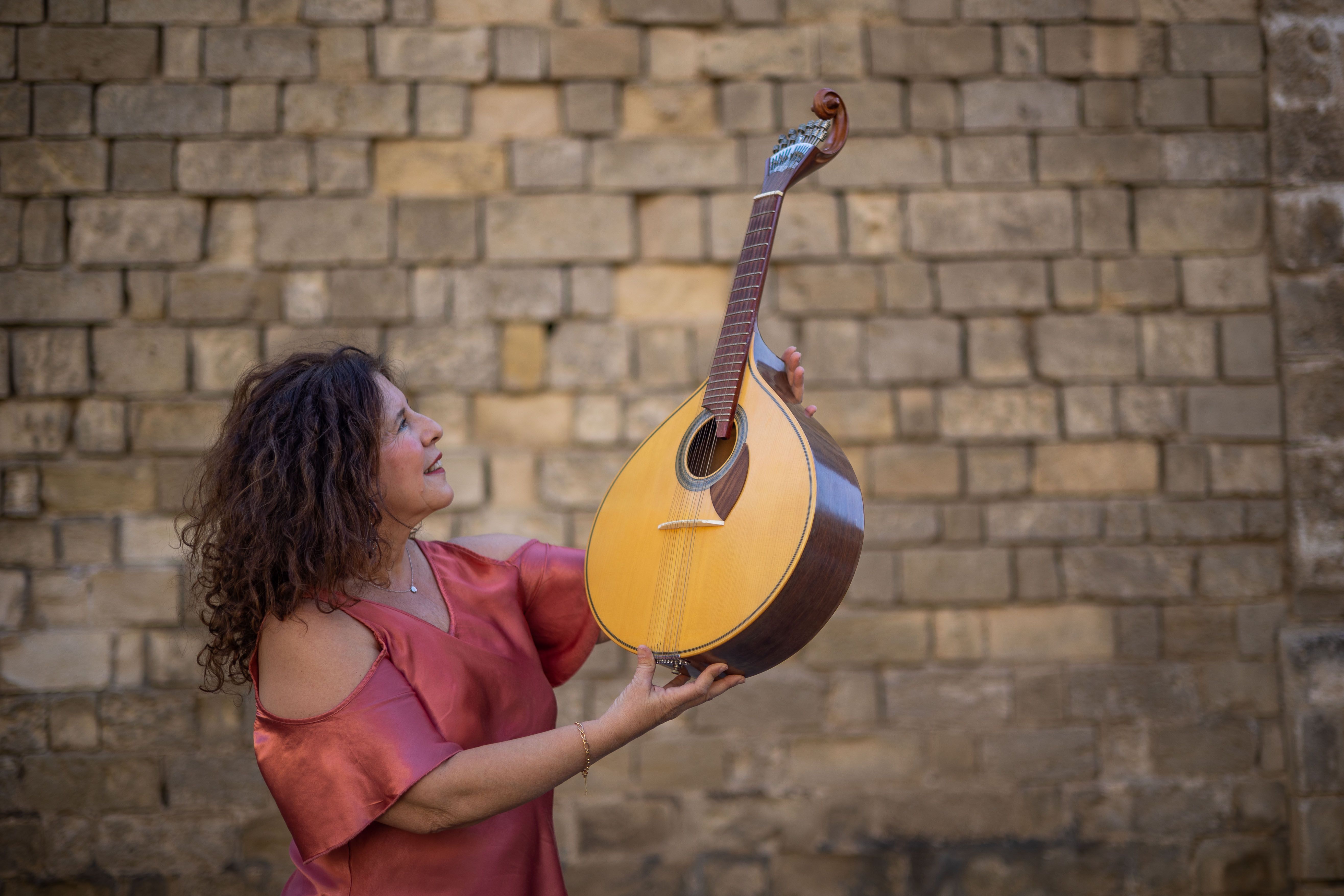 Ana sujeta una guitarra portuguesa, esencial en el fado.
