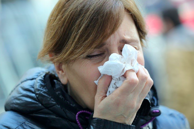 Una mujer estornudando.   ¿Por qué nos duelen los músculos cuando contraemos la gripe o la covid-19?